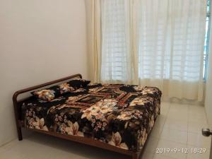 瓜拉弄宾HOMESTAY EIJAZ KUALA ROMPIN的一间卧室配有一张带花卉床罩的床