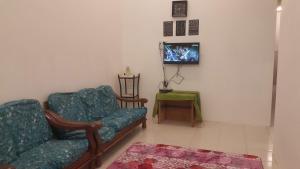 瓜拉弄宾HOMESTAY EIJAZ KUALA ROMPIN的客厅配有两把椅子和电视