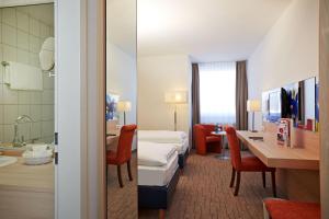 下恩豪森尼登豪森威斯巴登H+酒店的配有一张床和一张书桌的酒店客房