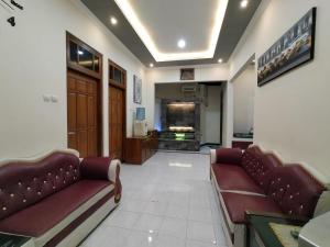 日惹Abadi Homestay的大厅,在大楼里设有两张沙发和一台电视机