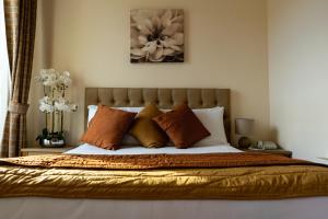 特里姆Brogans Bar & Hotel的卧室内的一张带橙色和白色枕头的床