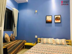 迪石STAY hostel 2 - 350m from the ferry的一间卧室设有两张床和蓝色的墙壁