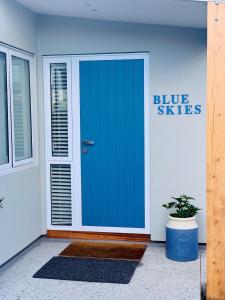皇后镇Blue Skies Guest Accommodation的建筑物的蓝色门,上面有标志