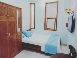 绥和市Khách sạn Nghinh Phong Beach Tuy Hòa的一间卧室配有一张床和一个木制橱柜