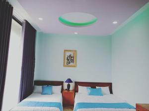绥和市Khách sạn Nghinh Phong Beach Tuy Hòa的一间卧室设有两张床和绿色的天花板