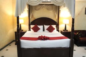 迪拜ORIENTAL CORNER HOTEL APARTMENTS LLC的一间卧室配有一张大床,上面有红色的弓