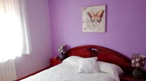Peral de Arlanza3 bedrooms house with enclosed garden at Peral de Arlanza的卧室配有一张床上,墙上挂着蝴蝶照片
