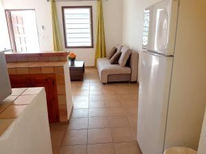 Happy BayOne bedroom appartement with furnished garden and wifi at La Savane 2 km away from the beach的带冰箱的厨房和带沙发的客厅