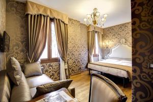 威尼斯多姆斯卡瓦尼斯酒店的一间卧室配有一张床、一张桌子和一个窗户。