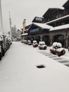 库马约尔iH Hotels Courmayeur Mont Blanc的大楼前的积雪覆盖的停车场
