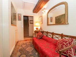 布里德波特Colly Cottage的客厅配有红色的沙发和镜子