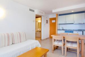 伊维萨镇大海与沙滩公寓的客厅配有床和桌椅