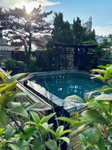 台北水都溫泉會館 的花园内带凉亭的游泳池