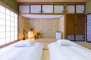 富士河口湖Villa RAKUWA Bettei的带窗户的客房内的两张床