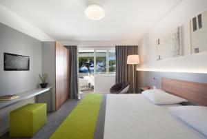 弗尔萨尔Maistra Select Pineta Hotel的酒店客房,配有一张绿地毯床