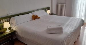 仕格莱Hotel del Trueno的一张白色大床,带两条毛巾和两盏灯