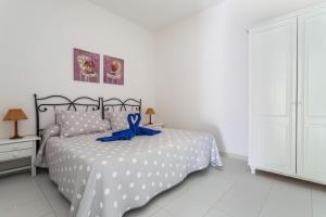塞博河畔卡莱塔El Sombrerito 1的一间卧室配有一张带蓝色丝带的床