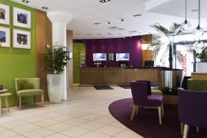 奥尔堡奥尔堡市斯堪迪克酒店的大堂设有紫色和绿色的墙壁和椅子