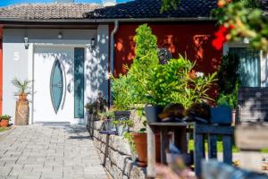 美因河畔克林根贝格Villa Croatia & Restaurant Adria的一座有花草的白色门的房子