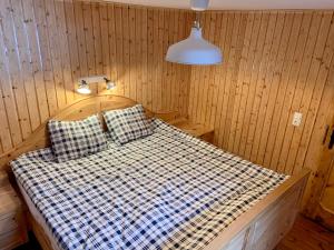 SchmirnSchmirnhaus的木制客房内的一张床位,配有台灯和枕头