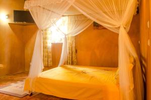 圣玛丽Villa Paradis的一间卧室配有一张天蓬床和窗户