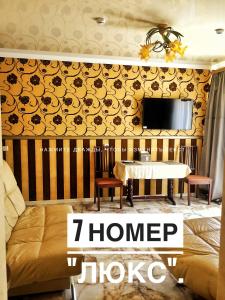 新切尔卡斯克Гостевой дом ДАЧА的一间设有桌子的房间和墙上的电视