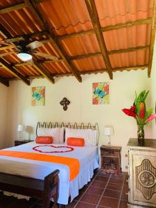 Caluco塞莫天堂度假屋的一间卧室配有一张带橙色和白色棉被的床