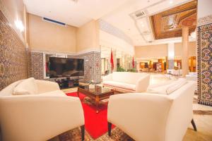 梅克内斯Hotel Menzeh Dalia的客厅配有白色椅子和平面电视