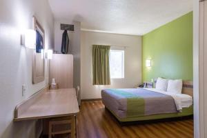 雪松城锡达城6号汽车旅馆的配有一张床和一张书桌的酒店客房