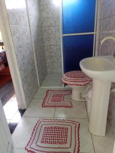 苏佩拉古伊Pousada Serena Superagui的一间带水槽和卫生间的浴室以及2个地毯。