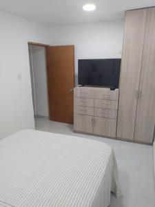 塔甘加Emvacamo'的一间卧室配有一张床和一台平面电视