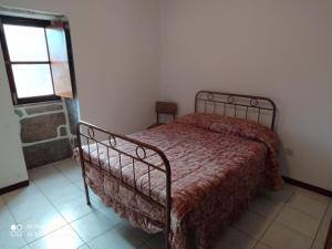 阿尔库什迪瓦尔德维什Casa Prado de Mó的一间卧室配有一张带红色棉被的床和窗户。