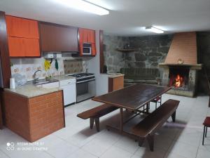 阿尔库什迪瓦尔德维什Casa Prado de Mó的厨房配有木桌和壁炉。