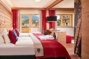 萨尔巴赫Hotel Hasenauer的一间卧室配有两张带红色窗帘的床和窗户。