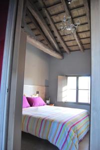 圣焦尔焦迪诺加罗b & b Alle 3 palme的一间卧室配有一张带粉色床单和吊灯的床。