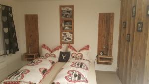 阿罗萨Chalet Waldperle的一间卧室配有两张带红白色枕头的床