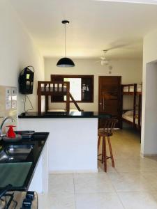 乌巴图巴Villa Palmeira Ubatuba的带柜台的厨房和带床的房间