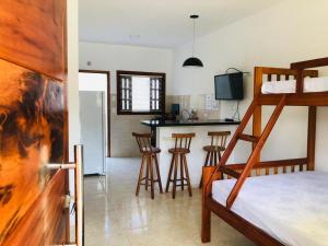 乌巴图巴Villa Palmeira Ubatuba的一间带双层床的卧室和一间带酒吧的厨房