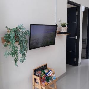班顿甘Villa Seruni Bandungan的挂在墙上的平板电视,上面有食物的箱子