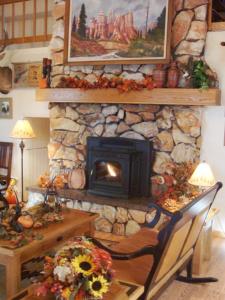 布莱斯峡谷布莱斯峡谷松树酒店的客厅设有石制壁炉、木桌和桌子。