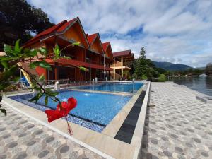 图克图克马斯别墅酒店的一座带游泳池的度假村,位于一座建筑旁边