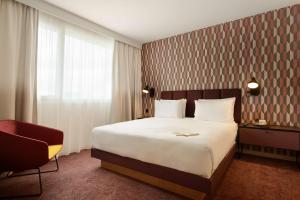 鲁瓦西昂法兰西Hyatt House Paris Charles de Gaulle Airport的配有一张床和一把椅子的酒店客房