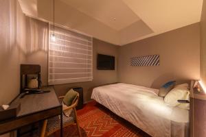 仓敷Royal Park Hotel Kurashiki的一间卧室配有一张床、一张书桌和一个窗户。