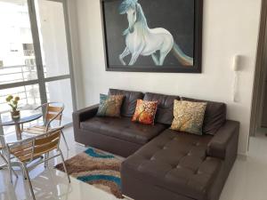 吉拉尔多特Acogedor apartamento en Girardot, fresco y tranquilo的客厅配有沙发和马术画