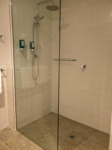 纳甘比尼冈比海滨汽车旅馆的浴室里设有玻璃门淋浴