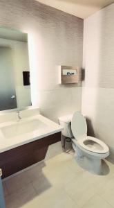 南普莱恩菲尔德花园行政酒店的浴室配有卫生间、盥洗盆和浴缸。