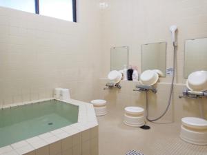 白马村Pilot Lodge的带浴缸、两个卫生间和淋浴的浴室