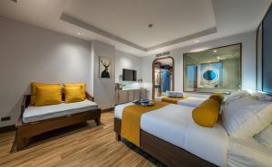 曼谷Graph Hotels Bangkok的酒店客房 - 带两张带黄色枕头的床
