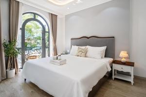 胡志明市The Royal Homies - Phu My Hung的白色的卧室设有一张大床和一个窗户