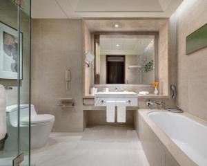 唐山唐山香格里拉的一间带水槽、浴缸和卫生间的浴室